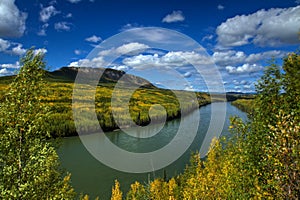 Brilliant autumn colors line the powerful Liard River