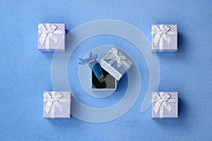 Brilliant blue usb flash memory card with a blue bow lies in a small gift box in blue with a small bow on a blanket of soft and fu