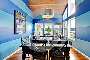 Brilliant dinning room with blue stripped walls.