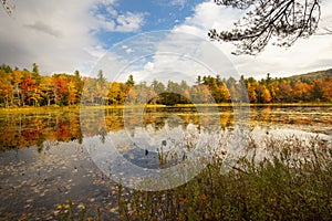 Brilliant fall foliage around Morey Pond in Wilmot, New Hampshire