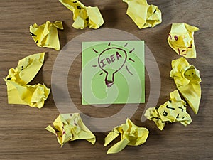 Brilliant Idea From Failed Attempts - Fresh idea on a green note among crumpled paper. Symbolizes brainstorming, problem-solving,