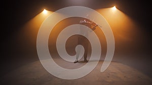 Brilliant male musician standing on stage and playing violin