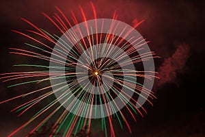 Brilliant red and green fireworks against the backdrop of the night sky