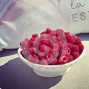 Raspberries in cute trinquet on a hot sunny summer day photo