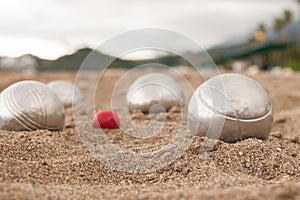 Brilliant silver balls for a bocha on the sand.