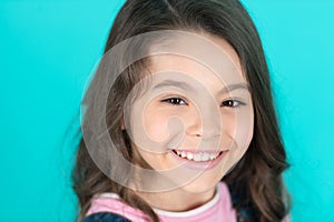 Brilliant smile. Kid happy carefree enjoy childhood. Child charming brilliant smile turquoise background. Kid girl long