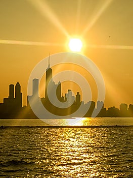 Brilliant sunbeams extend over skyline silhouette of Chicago