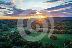 Brilliant Sunset in early fall over Sussex County NJ with large fields and foliage aerial