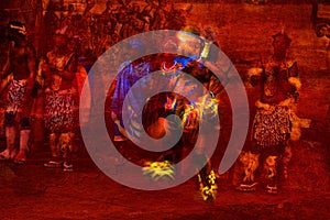 Brilliantly colored African Dancer Abstract in Motion and people in Native costume against a textured red background
