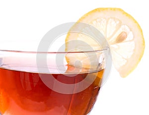 Brim of transparent cup with tea and lemon