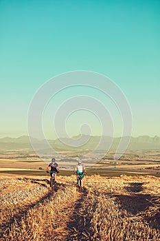 Bring back the adventure in your life. two cyclists out cycling in the countryside.