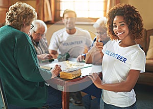 We bring smiles with every visit. Portrait of volunteers working with seniors at a retirement home.