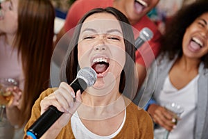 Bring the sound. Close up shot of beautiful young asian girl holding microphone and singing while playing karaoke with