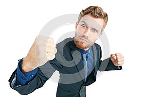 Bring it on. Studio portrait of an angry young businessman with his fists clenched ready to punch against a white