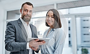 Bringing different expertise and perspectives together. Portrait of two businesspeople using a digital tablet together