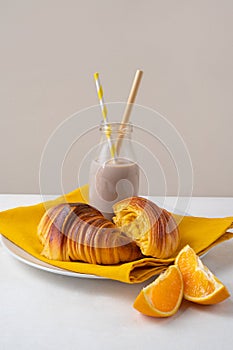Brioche croissants on a plate with chocolate milk