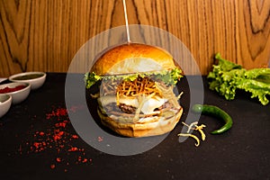 Brioche Cubana Burger with tomato sauce and green chilli isolated on table side view of fastfood