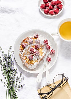 Brioche french toast with raspberry, powdered sugar and green tea. Cozy home still life, free time rest. On a light background, to