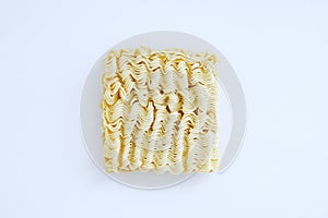 Briquette of dry Asian instant noodles on white plate. View from above