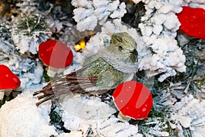 Bristle brush and stick bird with knitted scarf on flocked Christmas tree with bright red mushrooms