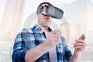 Bristled man in VR headset looking at transparent tablet