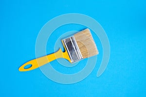 Bristly paint brush for painting and repair, on blue background