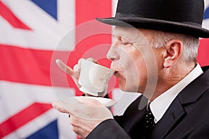 British businessman / city worker with bowler hat drinking tea.