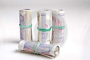 British currency. Four rolls of twenty pound notes held by rubber band