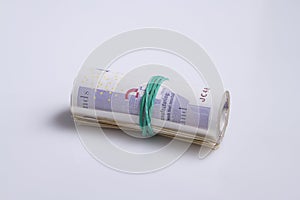 British currency. Roll of twenty pound notes held by rubber band