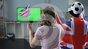 British fans watching football match on tv at home, supporting national team