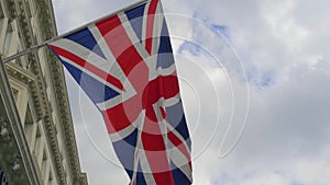 British flag close-up on a flagpole against a sky.