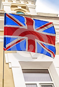 The British flag flies on the building of old hotel in the tourist city