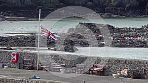 British flag waving halfmast at Cemaes, Wales - United Kingdom