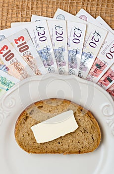 British money, piece of bread on plate. Food budget.