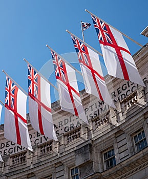 British naval white ensign flags flying at Admiralty Arch between The Mall and Trafalgar Square in the centre of London. UK