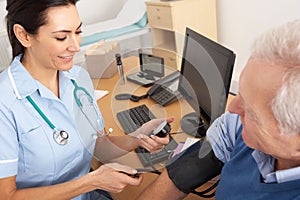 British nurse taking senior man's blood pressure photo