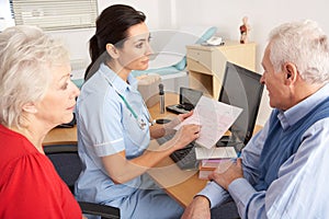 British nurse talking to senior couple