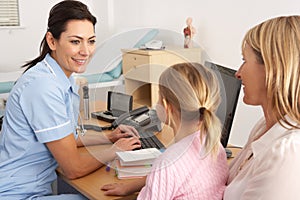 British nurse talking to young child and mother