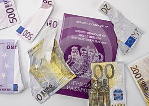 British passport next to broken euro notes