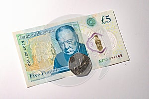 British pound coin on British pound banknotes