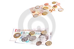 British Pound notes and coins and Euro notes and coins on white