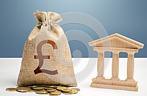 British pound sterling money bag and bank / government building. Budgeting, national financial system. Support businesses