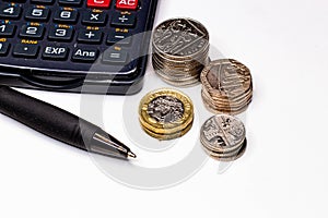 British pounds and pence coins and pen and calculator, business and currency