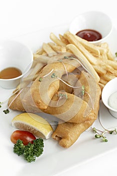 british traditional fish and chips meal in restaurant on white plate