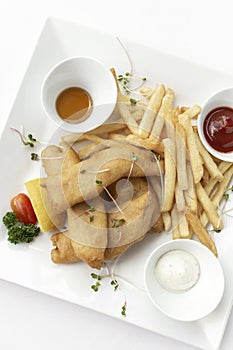 british traditional fish and chips meal in restaurant on white plate