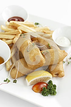 british traditional fish and chips meal in restaurant on white plate