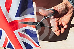 British woman angry with her English politicians denies her nationality by cutting British flag