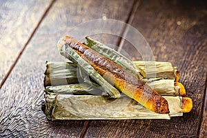 Broa made with corn and wrapped in banana leaf. Typical Brazilian dessert called bread-a-pique bread, Brazilian bread or corn