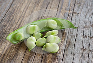 Broad beans on wooden table