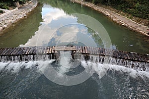 A broad dam spans across the river